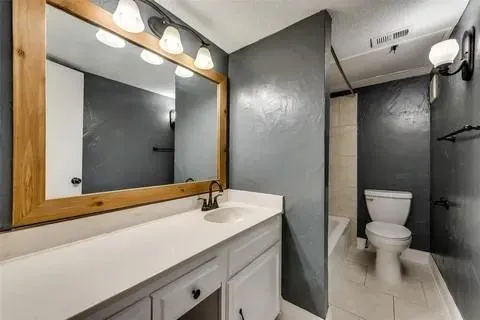 a bathroom with a sink a toilet and mirror