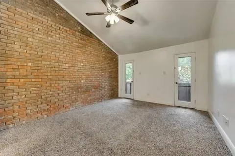 a view of an empty room and chandelier fan