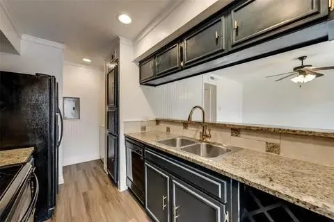 a kitchen with granite countertop stainless steel appliances a sink and refrigerator