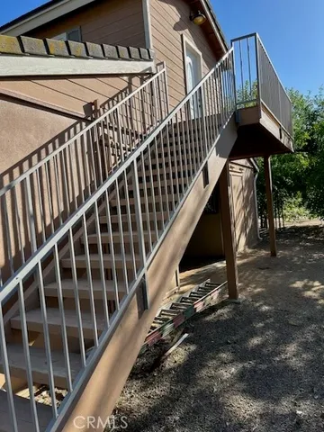 a view of staircase with railing and white walls