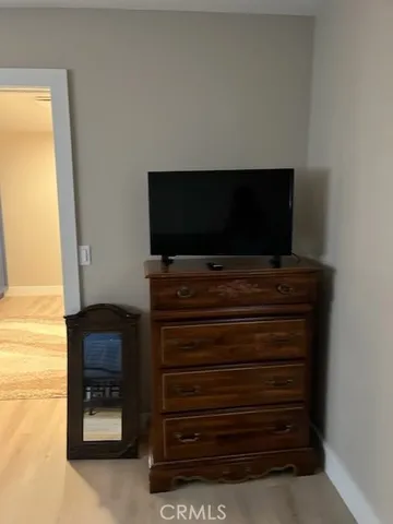 a living room with flat screen tv and dresser