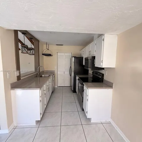 a kitchen with stainless steel appliances granite countertop a refrigerator and a stove