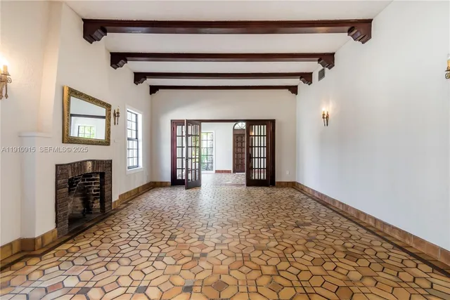 a view of an empty room with a fireplace and a window