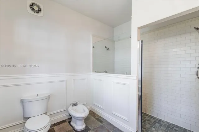 a bathroom with a toilet and a shower