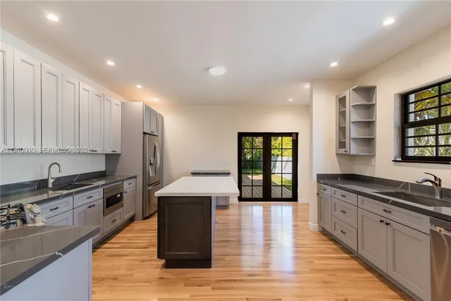a large kitchen with stainless steel appliances granite countertop a sink and cabinets