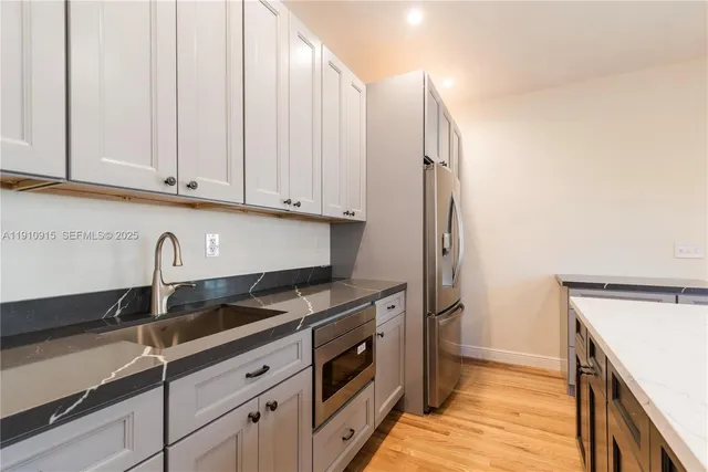 a kitchen with stainless steel appliances granite countertop a sink and a stove