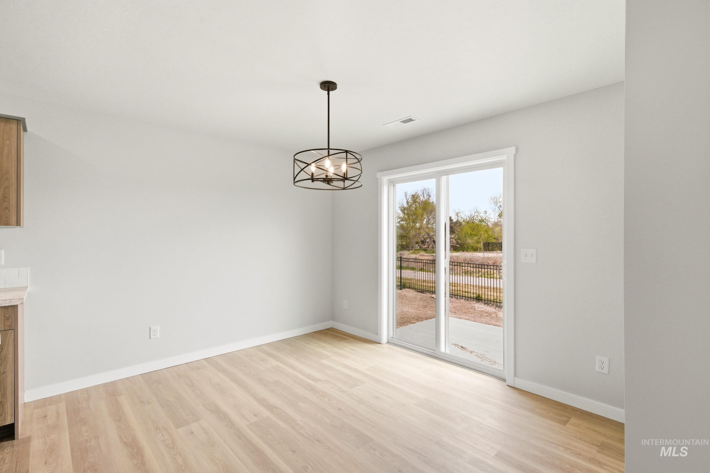 2446 West Fallon Loop Nampa, ID 83651 - Photo 7 of 19 Unfurnished dining area with light wood-style floors and suspended lighting