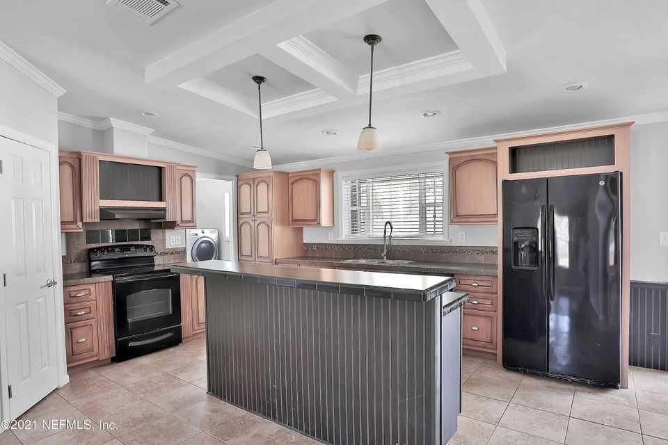 54445 Lawhon Road West Callahan, FL 32011 - Photo 5 of 6 a kitchen with stainless steel appliances granite countertop a refrigerator a stove a sink and a microwave