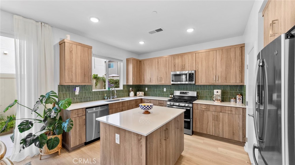 104 Lipizzan Lane Fallbrook, CA 92028 - Photo 10 of 53 a kitchen with a refrigerator a sink a stove top oven a refrigerator cabinets and wooden floor