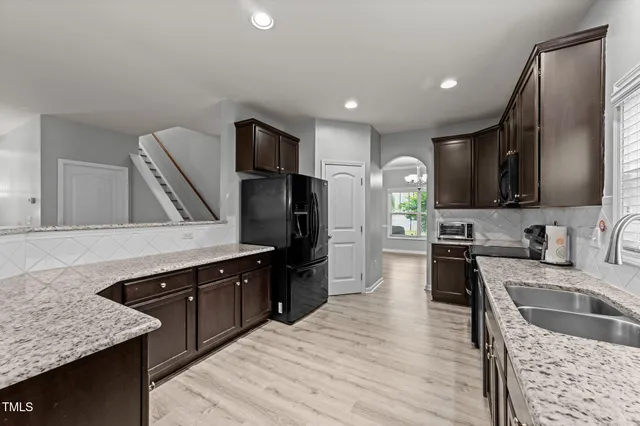 a open kitchen with stainless steel appliances granite countertop a sink stove and refrigerator