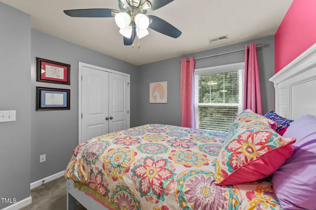 a bedroom with a bed chandelier and pink walls
