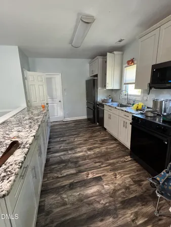 a large kitchen with kitchen island granite countertop a sink and a stove top oven
