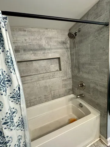 a bathroom with a bathtub and shower