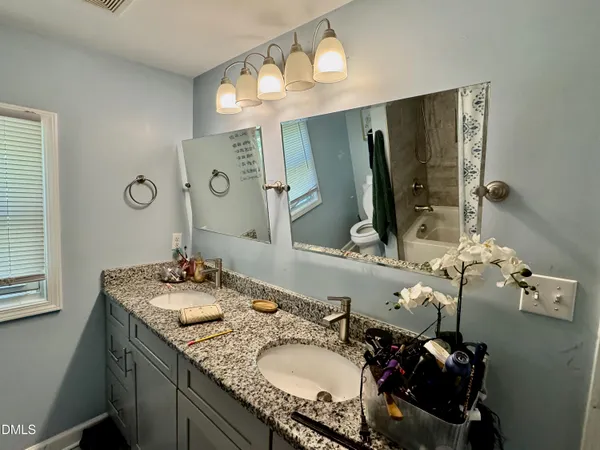 a bathroom with a granite countertop sink and a mirror
