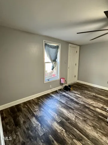 a view of a room with wooden floor and window