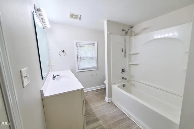 a bathroom with a tub sink and mirror