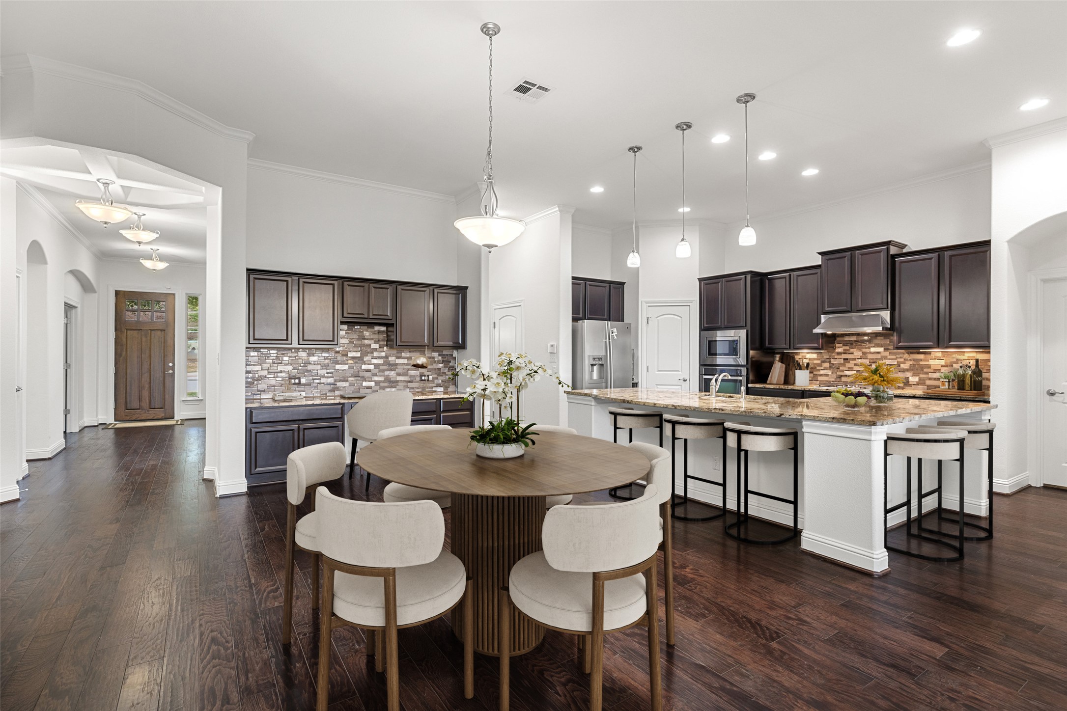 5612 Cherokee Draw Road Austin, TX 78738 - Photo 5 of 31 a kitchen with kitchen island granite countertop a dining table chairs wooden floor cabinets and stainless steel appliances