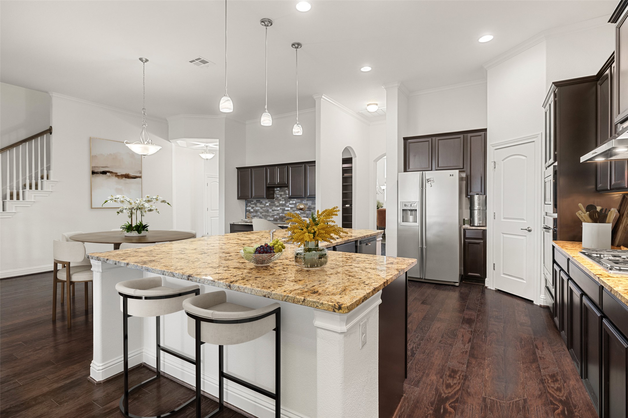 5612 Cherokee Draw Road Austin, TX 78738 - Photo 10 of 31 a kitchen with stainless steel appliances kitchen island granite countertop a kitchen island a stove a refrigerator and a view of dining room