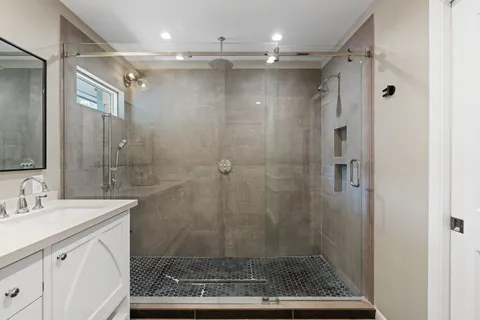 a bathroom with a shower sink and mirror