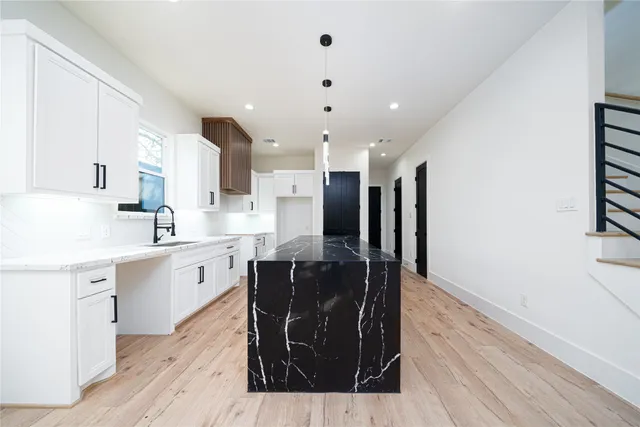 a kitchen with stainless steel appliances granite countertop a sink stove and wooden floor