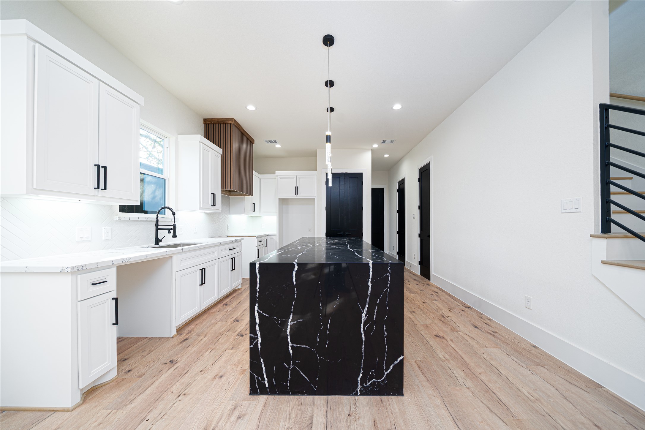 2429 Parker Road Houston, TX 77093 - Photo 5 of 17 a kitchen with stainless steel appliances kitchen island granite countertop a refrigerator a sink a stove and white cabinets with wooden floor