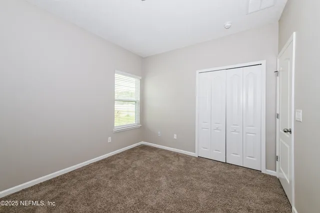 an empty room with windows and closet