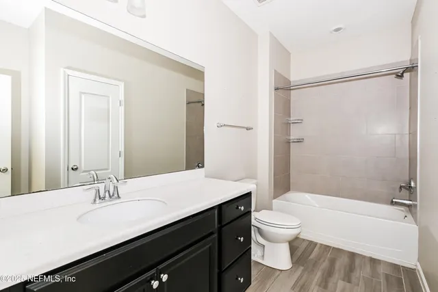 a bathroom with a granite countertop sink toilet a large mirror and shower