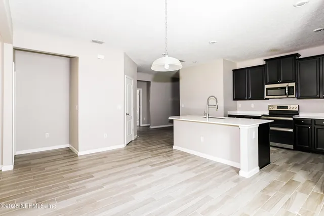 a kitchen with granite countertop a refrigerator and a stove top oven