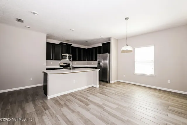 a kitchen with stainless steel appliances a refrigerator sink and microwave