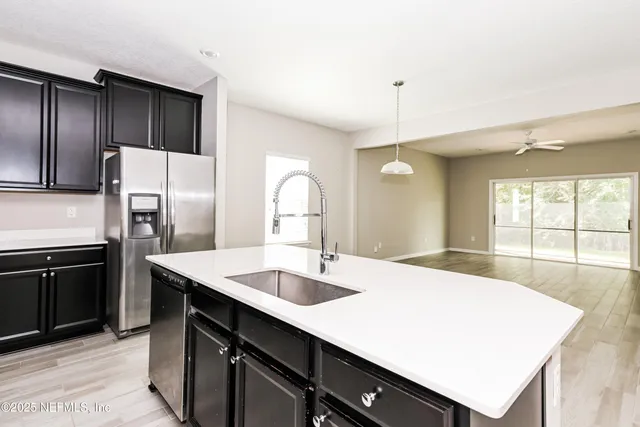 a kitchen with a refrigerator sink and cabinets