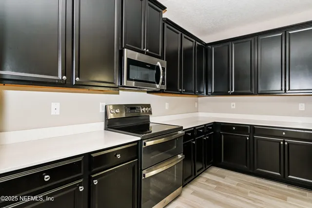 a kitchen with granite countertop wooden cabinets and stainless steel appliances