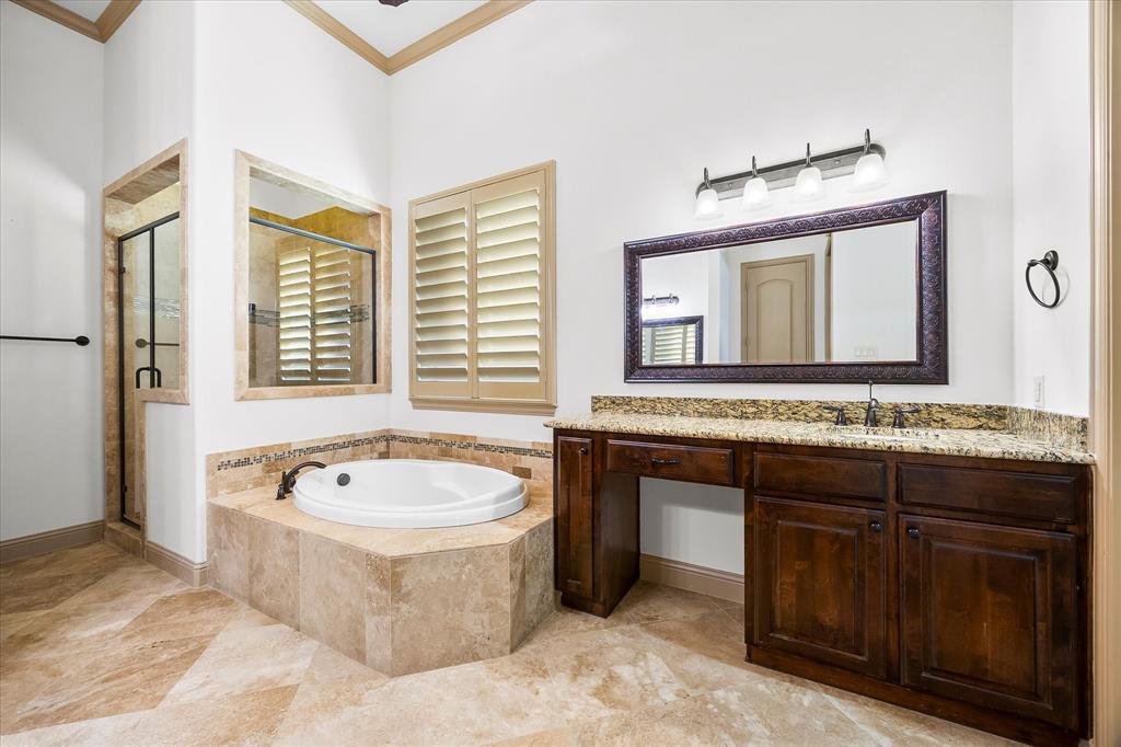 6814 Springwood Lane Garland, TX 75044 - Photo 22 of 35 a bathroom with a tub a sink and a mirror