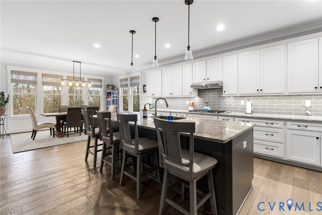 15060 Dordon Lane Midlothian, VA 23112 - Photo 10 of 35 a kitchen with stainless steel appliances granite countertop a stove a refrigerator a kitchen island a dining table and chairs with wooden floor