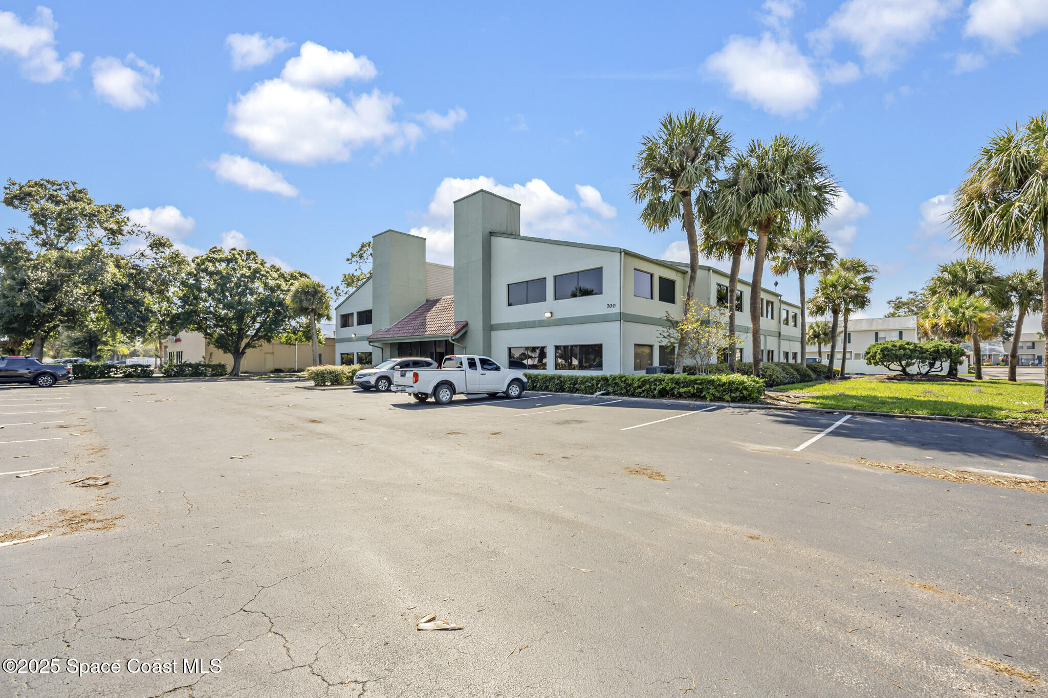 700 North Wickham Road, Unit 109 Melbourne, FL 32935 - Photo 2 of 13 a view of a house with a yard and a large tree