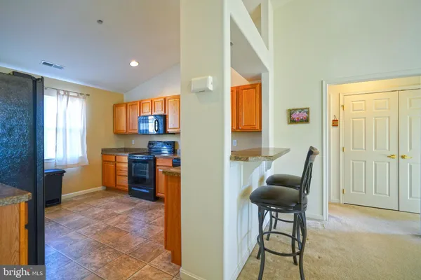 a open kitchen with stainless steel appliances granite countertop a refrigerator and a stove top oven