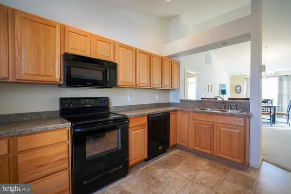 a kitchen with granite countertop wooden cabinets stainless steel appliances and a window