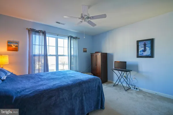 a bedroom with a bed furniture and a large window
