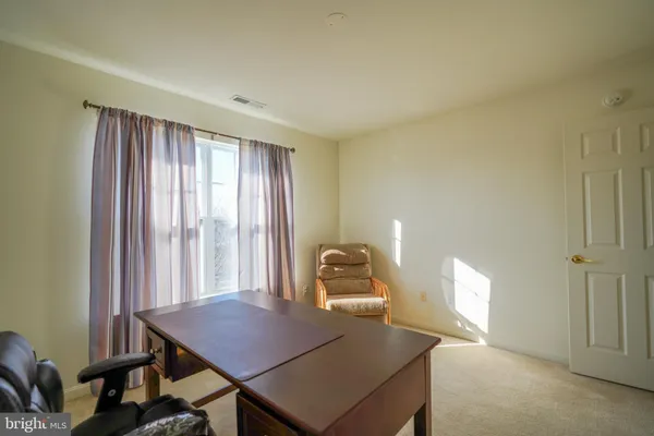 a view of a workspace with furniture and window