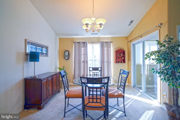 a view of a dining room with furniture and a potted plant