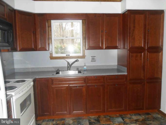 2921 Warehime Road Manchester, MD 21102 - Photo 20 of 30 a kitchen with stainless steel appliances granite countertop wooden cabinets a sink and a stove