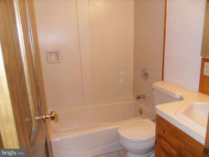 2921 Warehime Road Manchester, MD 21102 - Photo 30 of 30 a bathroom with a granite countertop toilet a sink and bathtub
