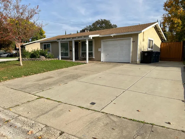 a view of house with backyard and tree