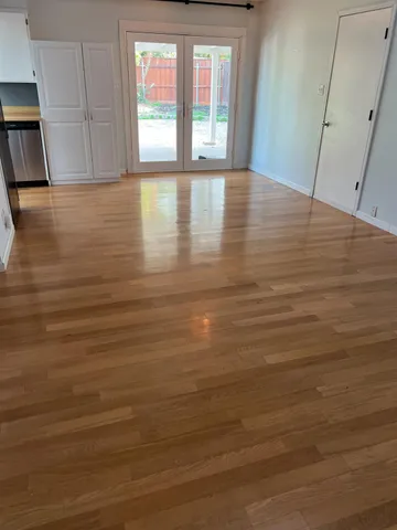 a view of an empty room with wooden floor