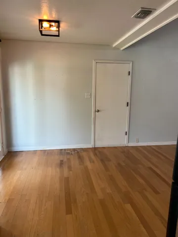 a view of a bedroom with wooden floor and a window