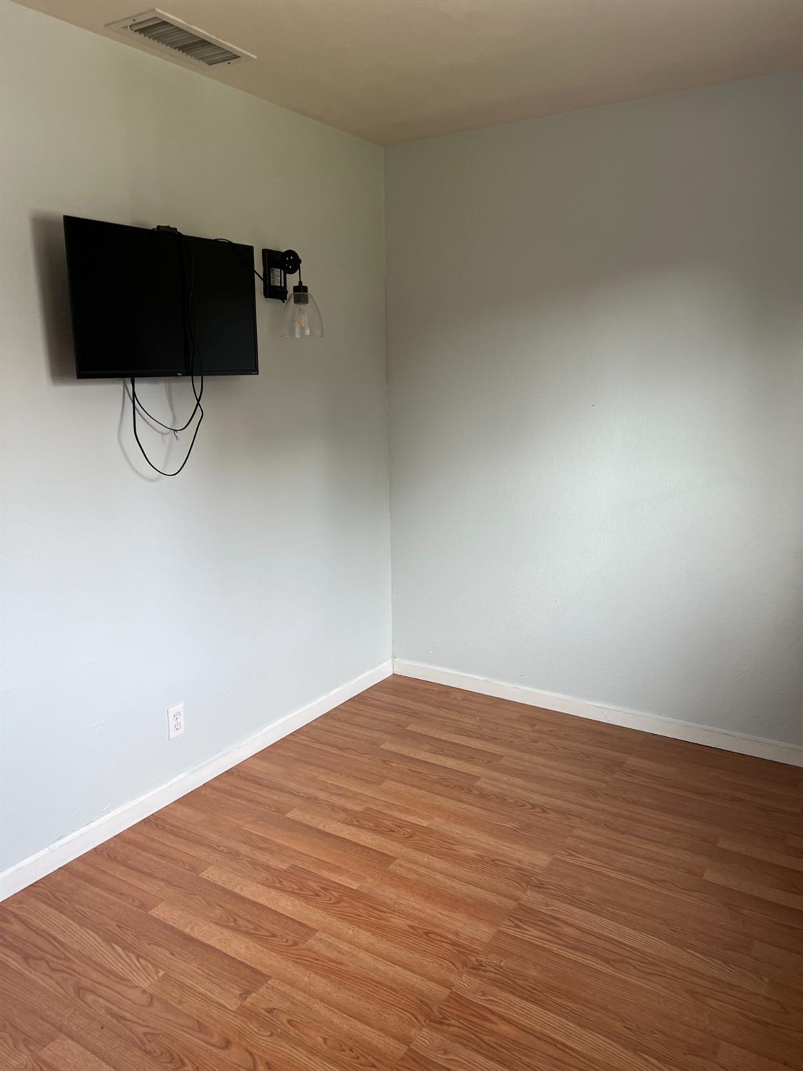 8024 Lesser Way Citrus Heights, CA 95621 - Photo 17 of 32 a view of a room with wooden floor and brick wall
