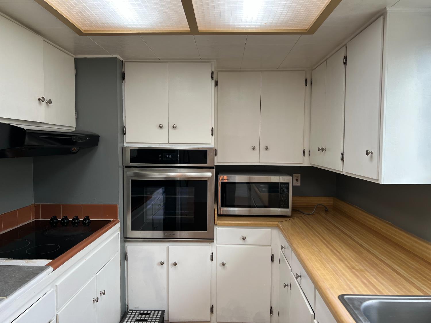 8024 Lesser Way Citrus Heights, CA 95621 - Photo 7 of 32 a kitchen with granite countertop white cabinets and stainless steel appliances