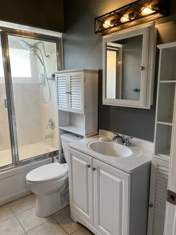 a view of an empty room with wooden floor and a ceiling fan