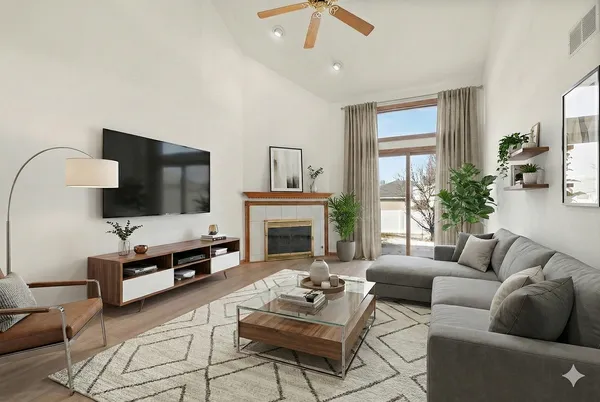 a living room with furniture a flat screen tv and a fireplace
