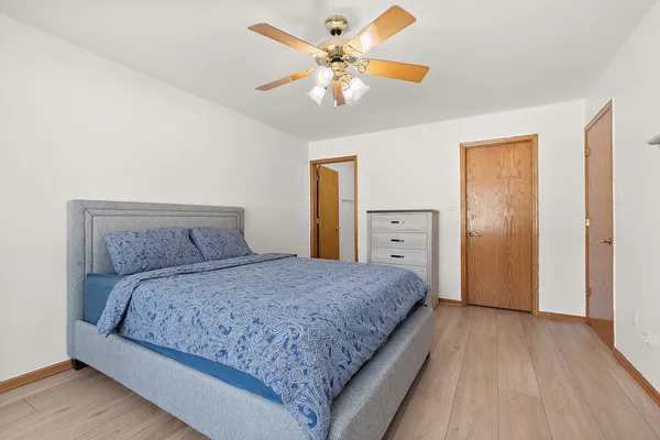 a bedroom with a large bed and a chandelier