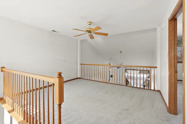 a view of a hallway with a chandelier fan